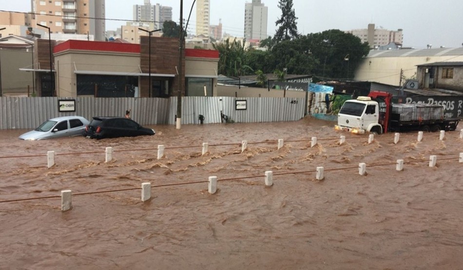 Temporal transborda córrego e alaga ponto de avenida em Passos