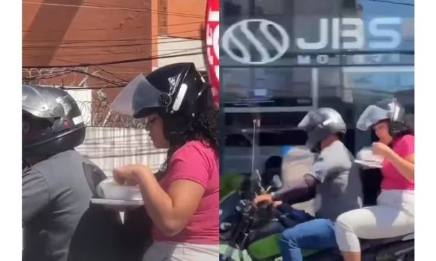 Mulher é flagrada no trânsito comendo marmita em garupa de moto e vídeo viraliza