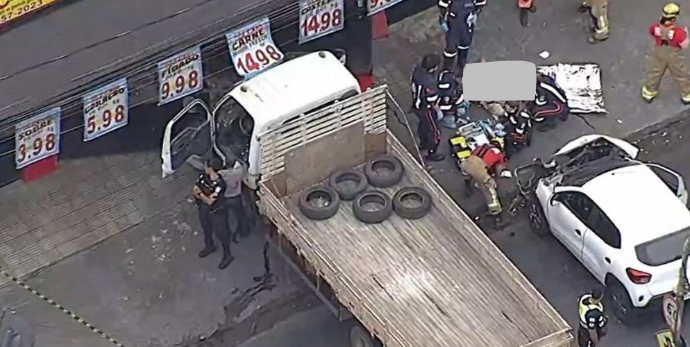 Acidente entre carro e caminhão mata pedestre prensado na porta de frigorífico em BH