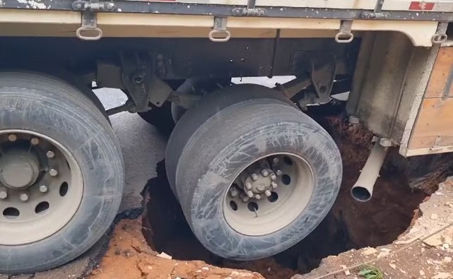 Caminhão afunda após asfalto ceder e abrir buraco enquanto veículo passava por rua de Passos